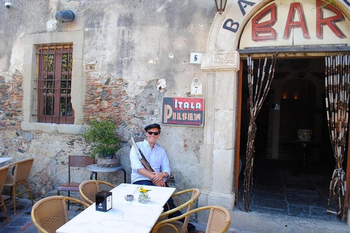 un uomo seduto a un tavolo fuori da un ristorante