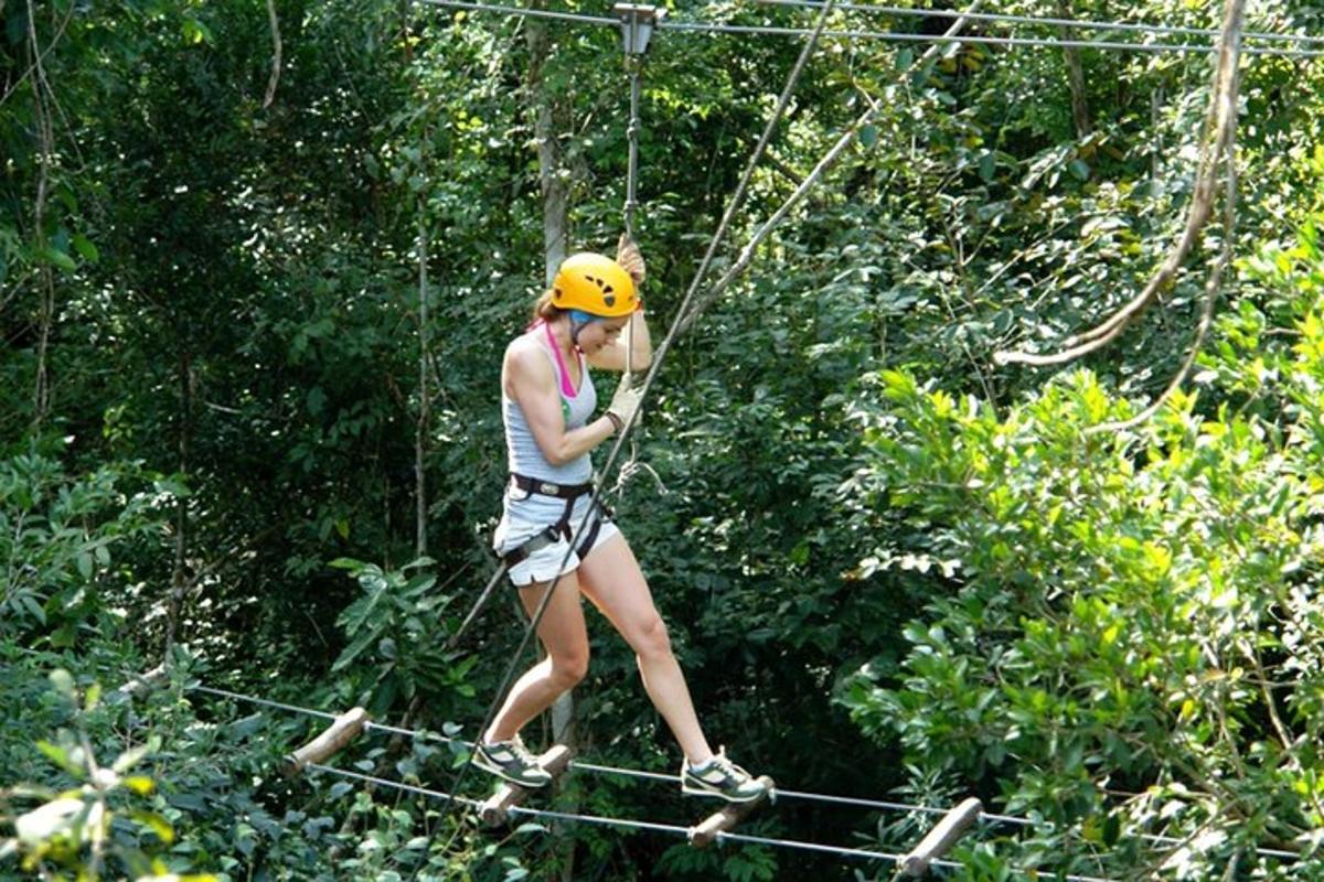 a woman on a zip line in the jungle