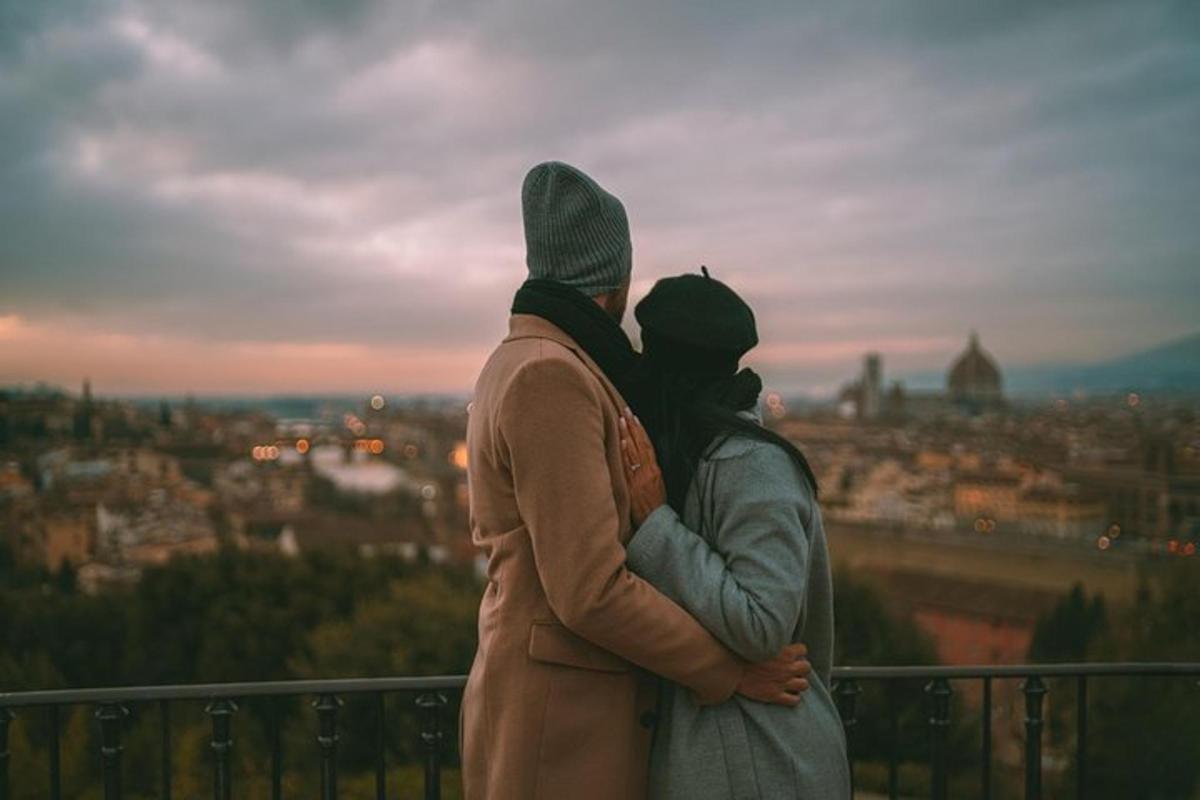 Egy férfi és egy nő az erkélyen állva nézik a várost