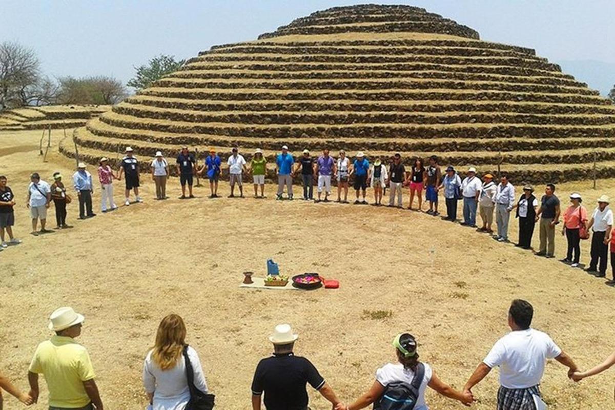 skupina lidí stojící před pyramidou