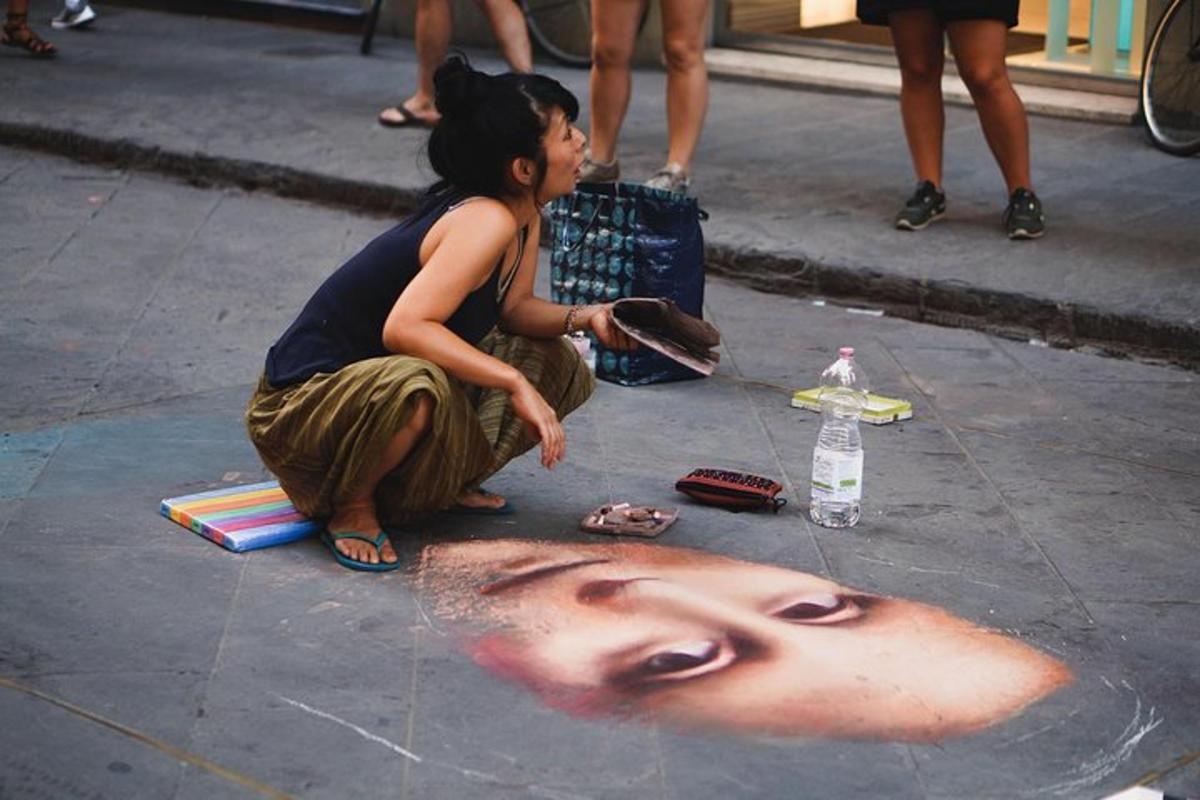 a little girl sitting on the ground with a face on the sidewalk