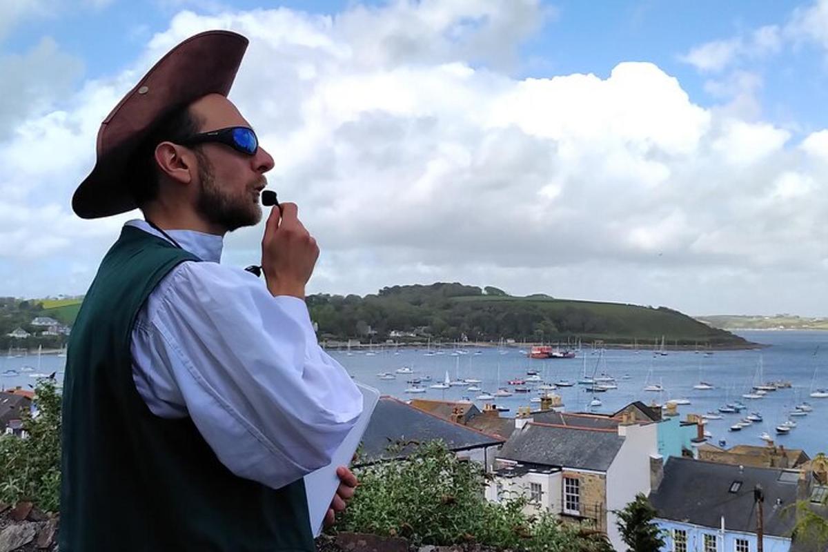 a man in a hat smoking a pipe with a harbor