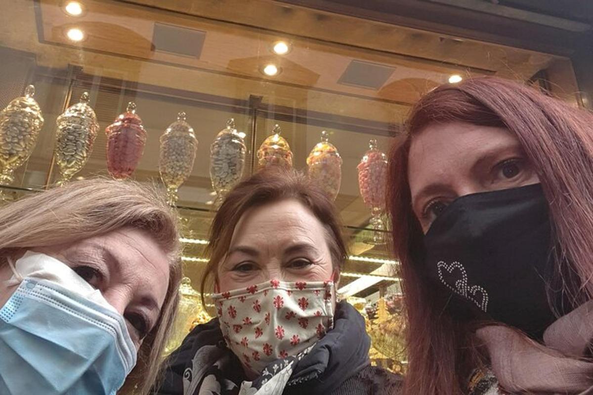 Kaks maske kandvat naist poe ees