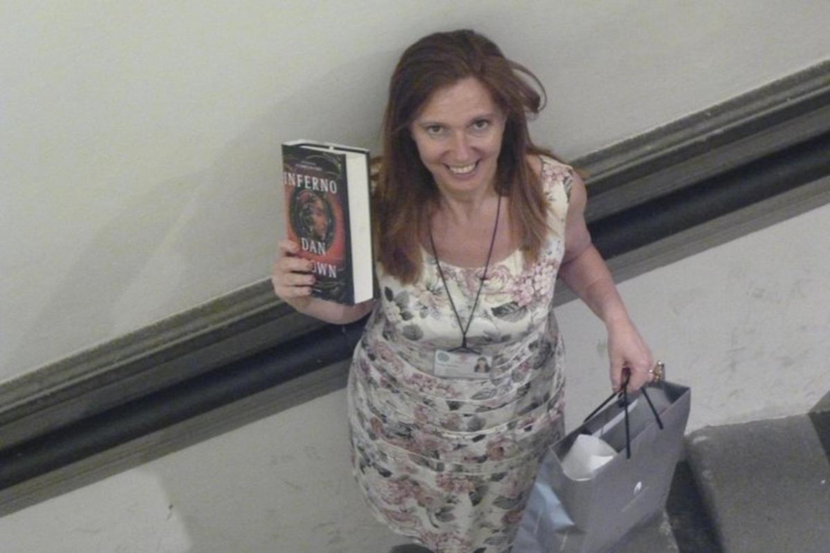 uma mulher está segurando um livro e uma bolsa