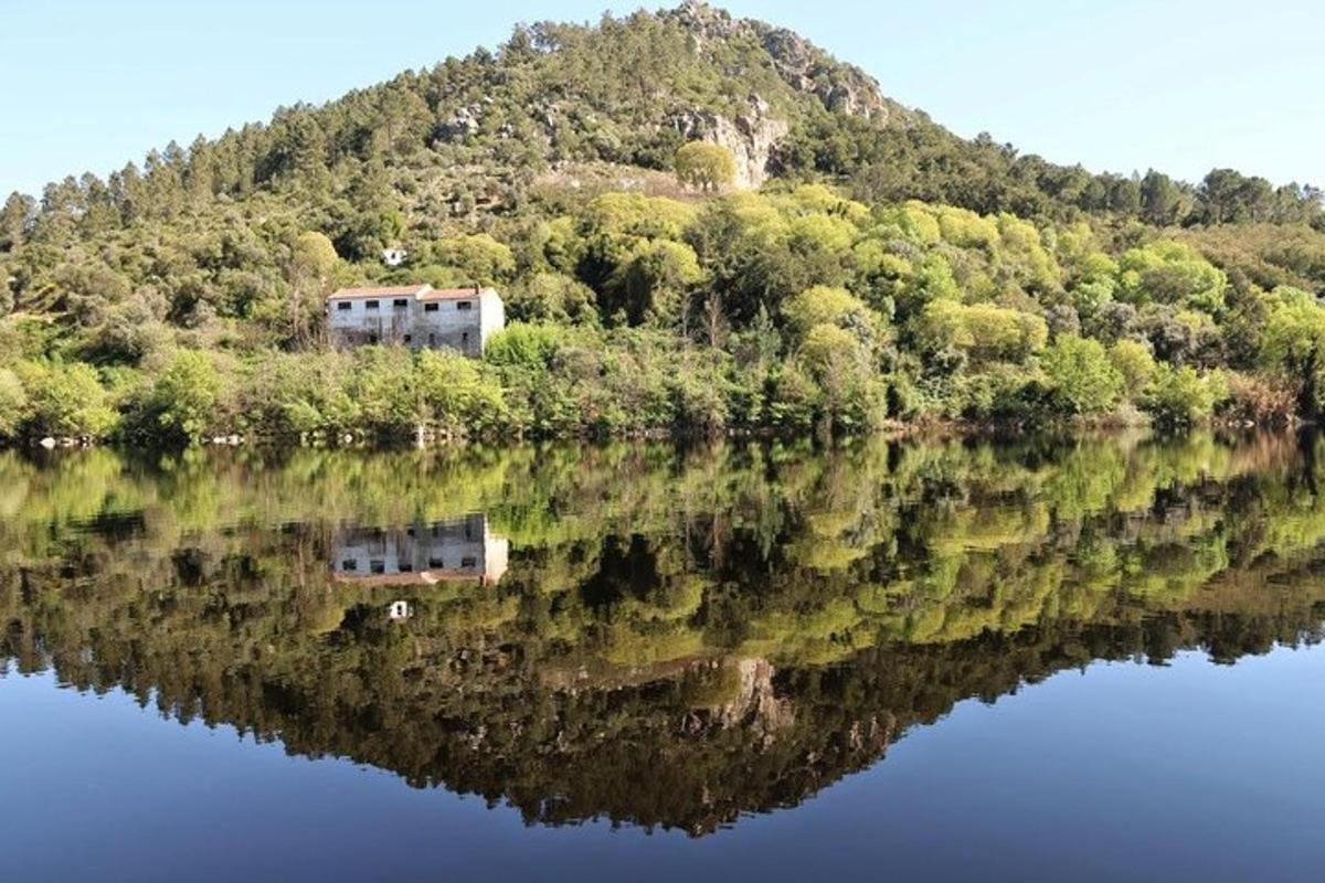 una casa su una collina vicino a uno specchio d'acqua