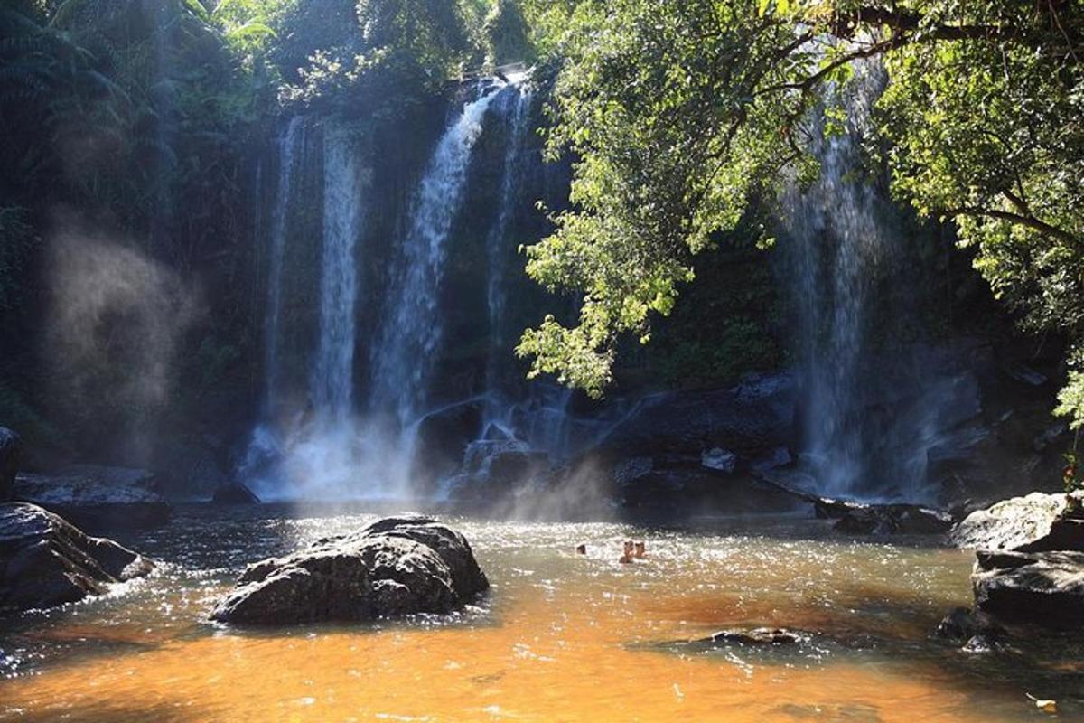 seseorang di dalam air di depan air terjun