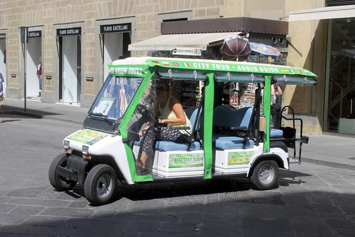 Una mujer conduciendo un carrito de golf verde y blanco