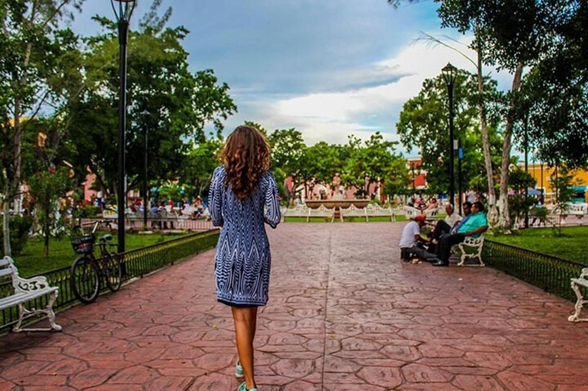 seorang wanita berpakaian berjalan di taman
