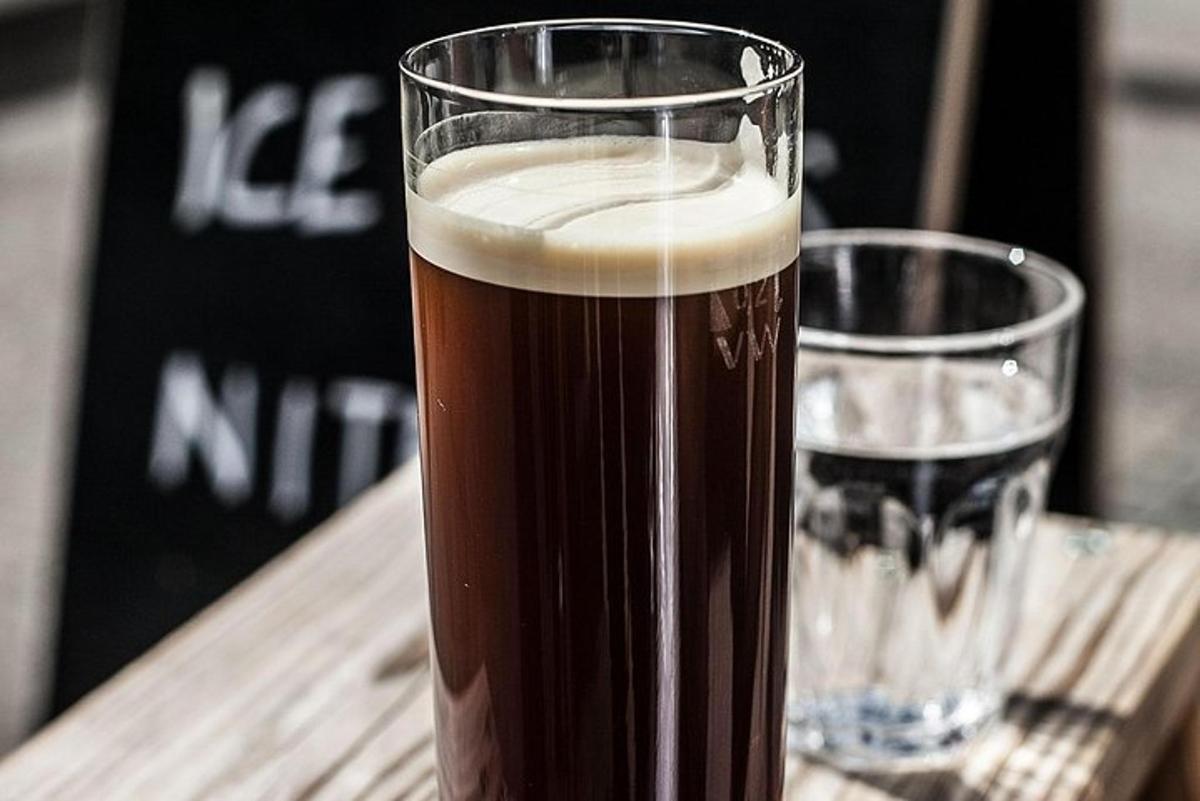 sklenice piva stojící na stole vedle sklenice vody