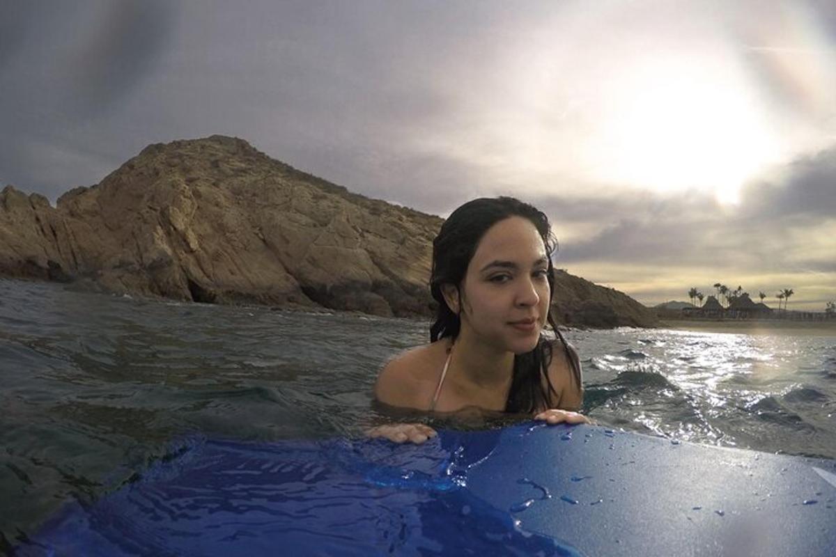 o femeie stând pe o placă de surf în apă