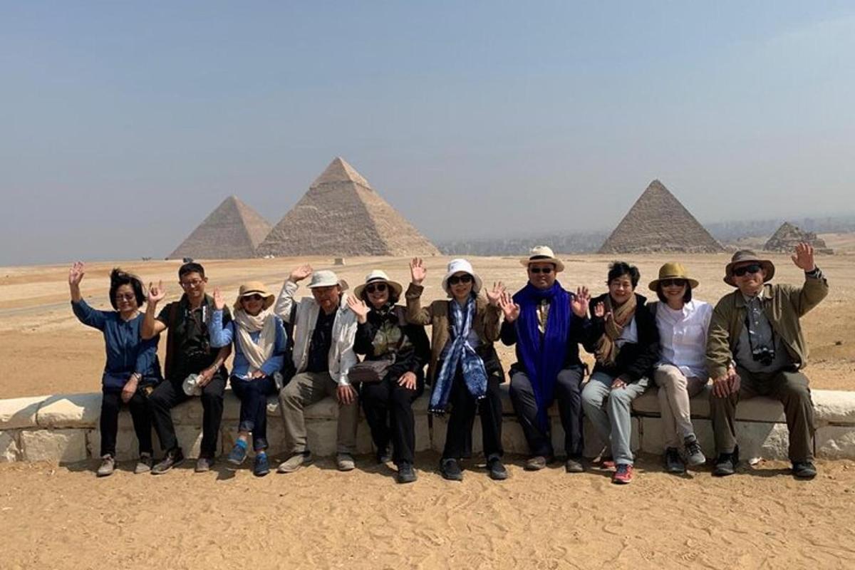 a group of people posing for a picture in front of pyramids