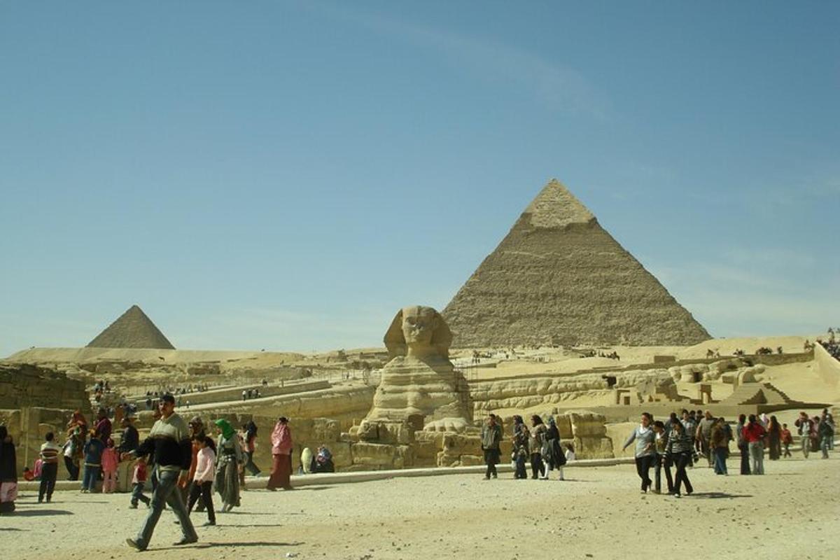 a group of people walking in front of the pyramids