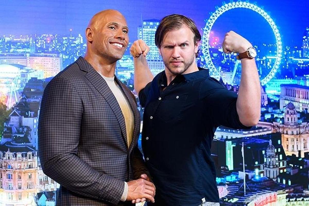 two men standing next to each other in a city