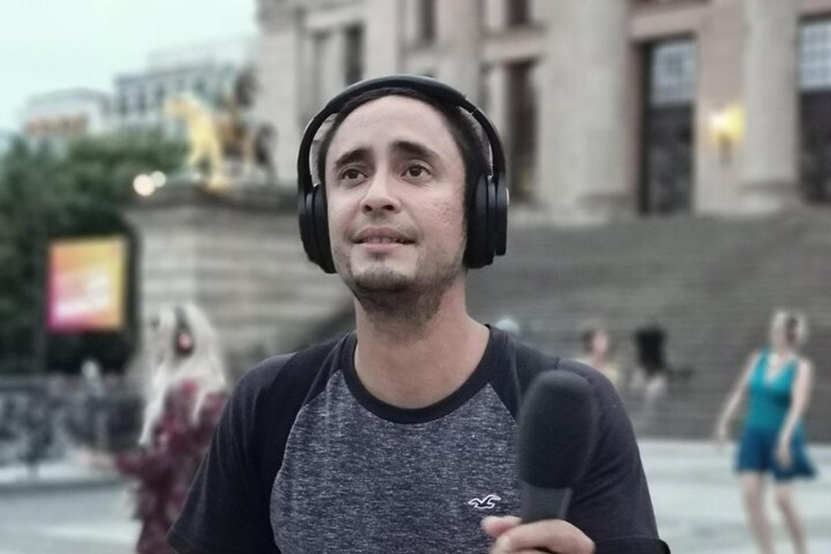 muž se sluchátky na uších stojící před budovou