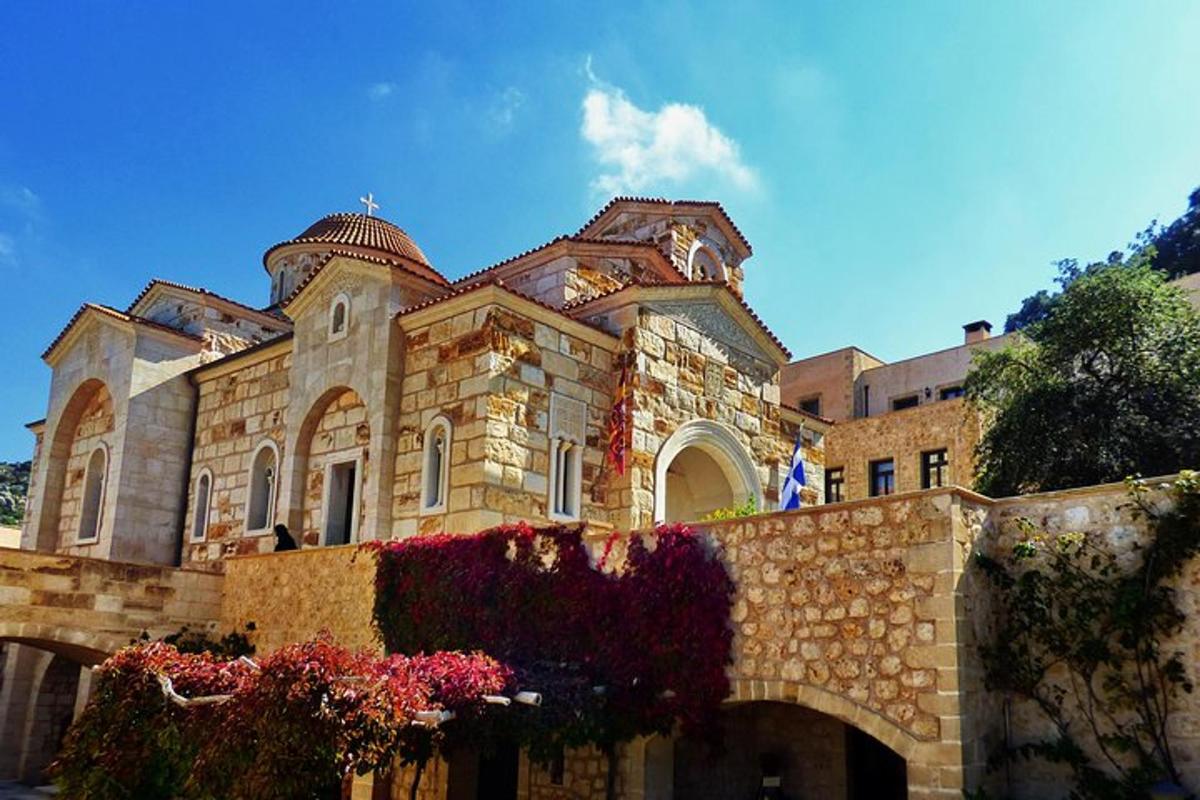 ένα μεγάλο πέτρινο κτίριο με λουλούδια μπροστά του