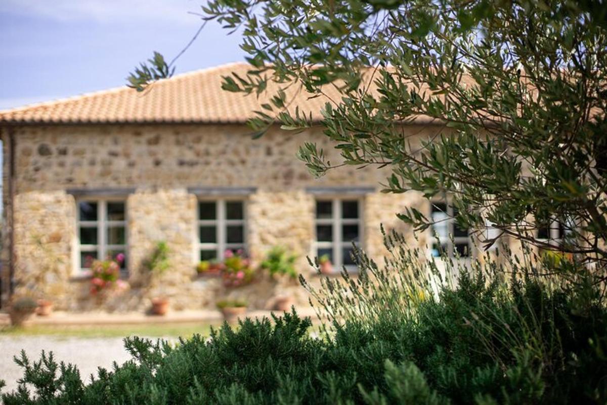 Una casa de piedra con un jardín delante.