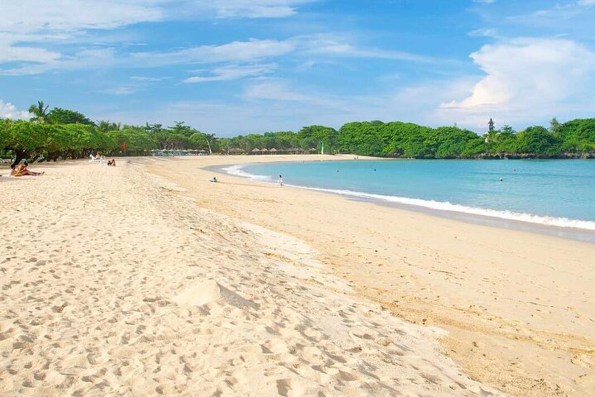 una spiaggia con persone sedute sulla sabbia e l'oceano