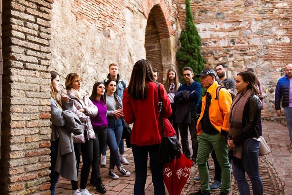 eine Gruppe von Menschen steht neben einer Backsteinmauer