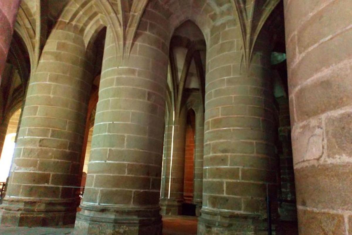 an aisle of a building with columns and arches