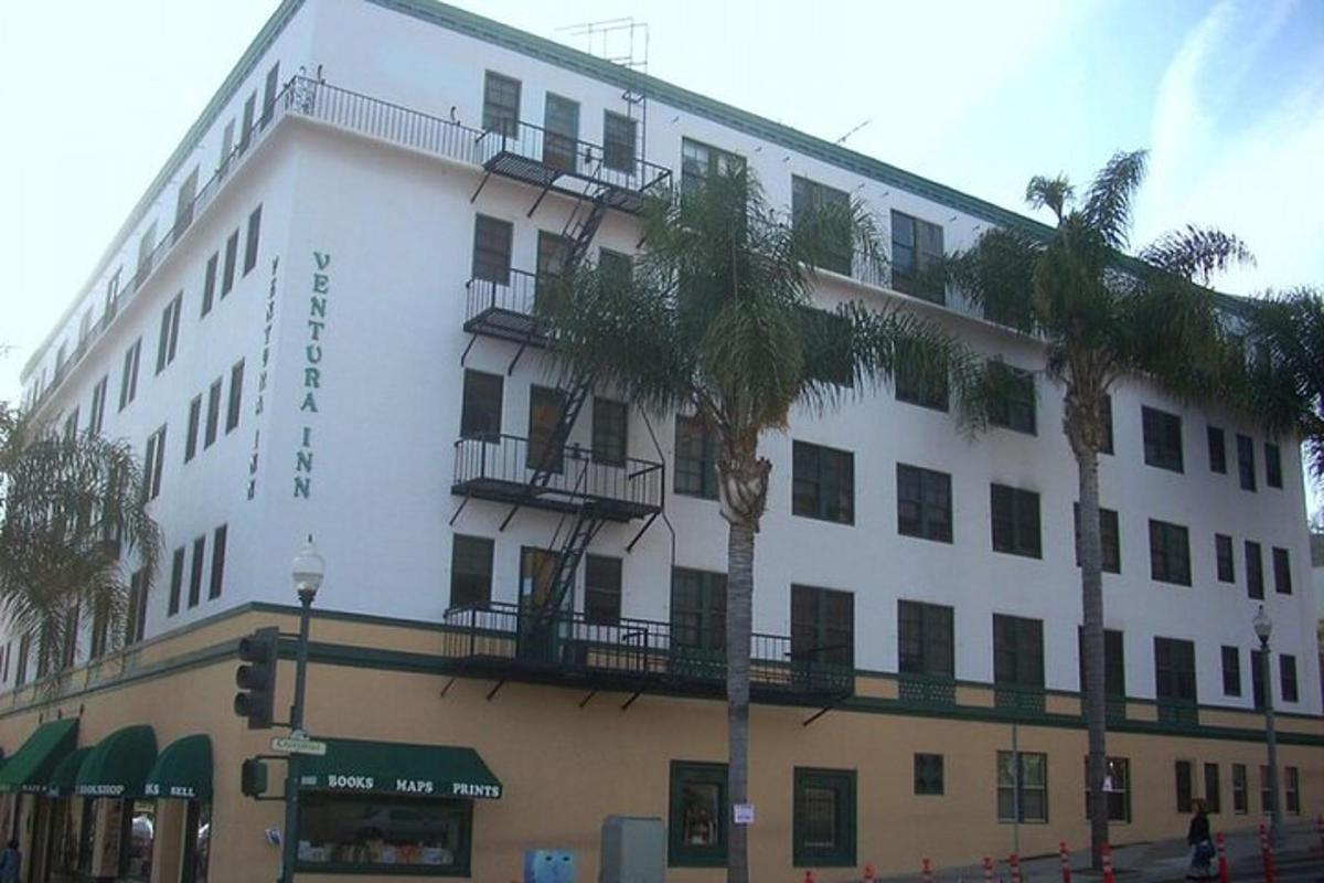 Un gran edificio blanco con palmeras delante.