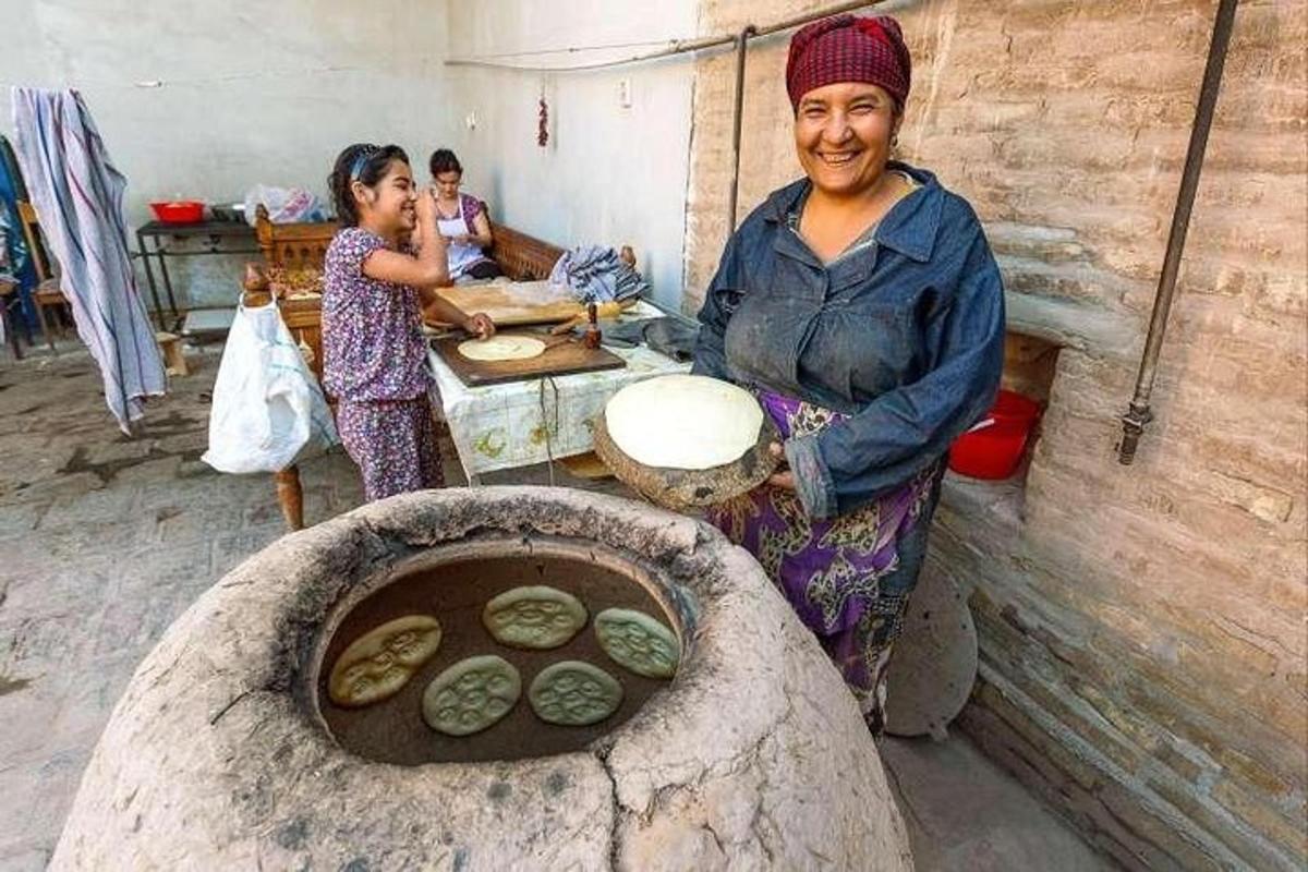a woman standing in a kitchen with a stone oven