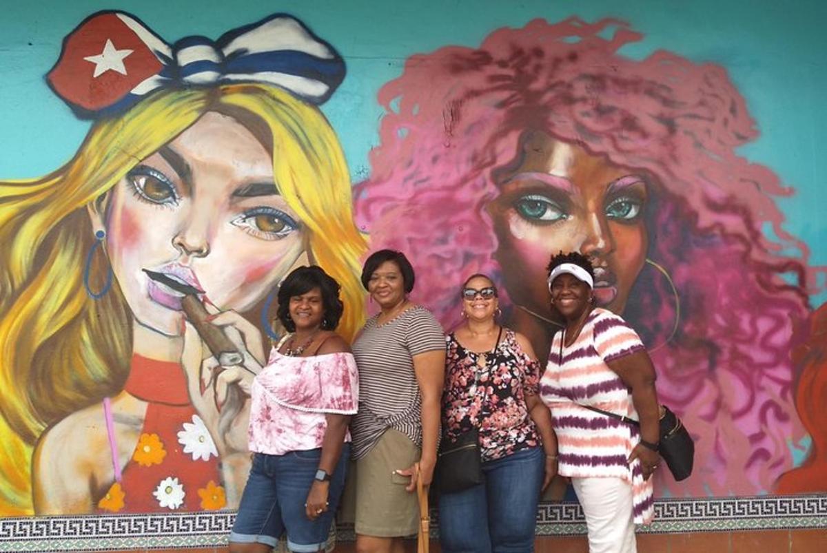 sekelompok wanita berdiri di depan mural