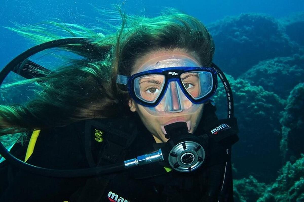 eine Frau mit Tauchermaske und Taucherbrille unter Wasser