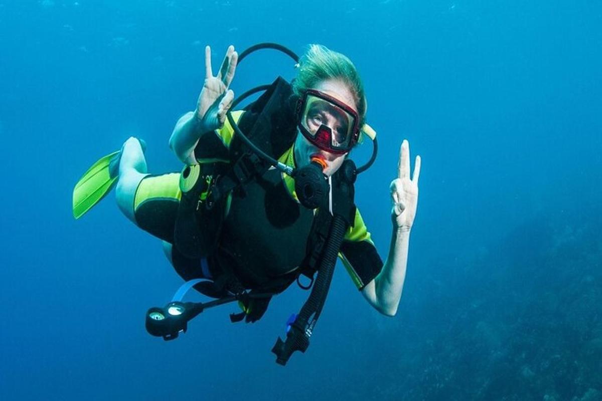una donna in tenuta da sub che fa il segno della pace