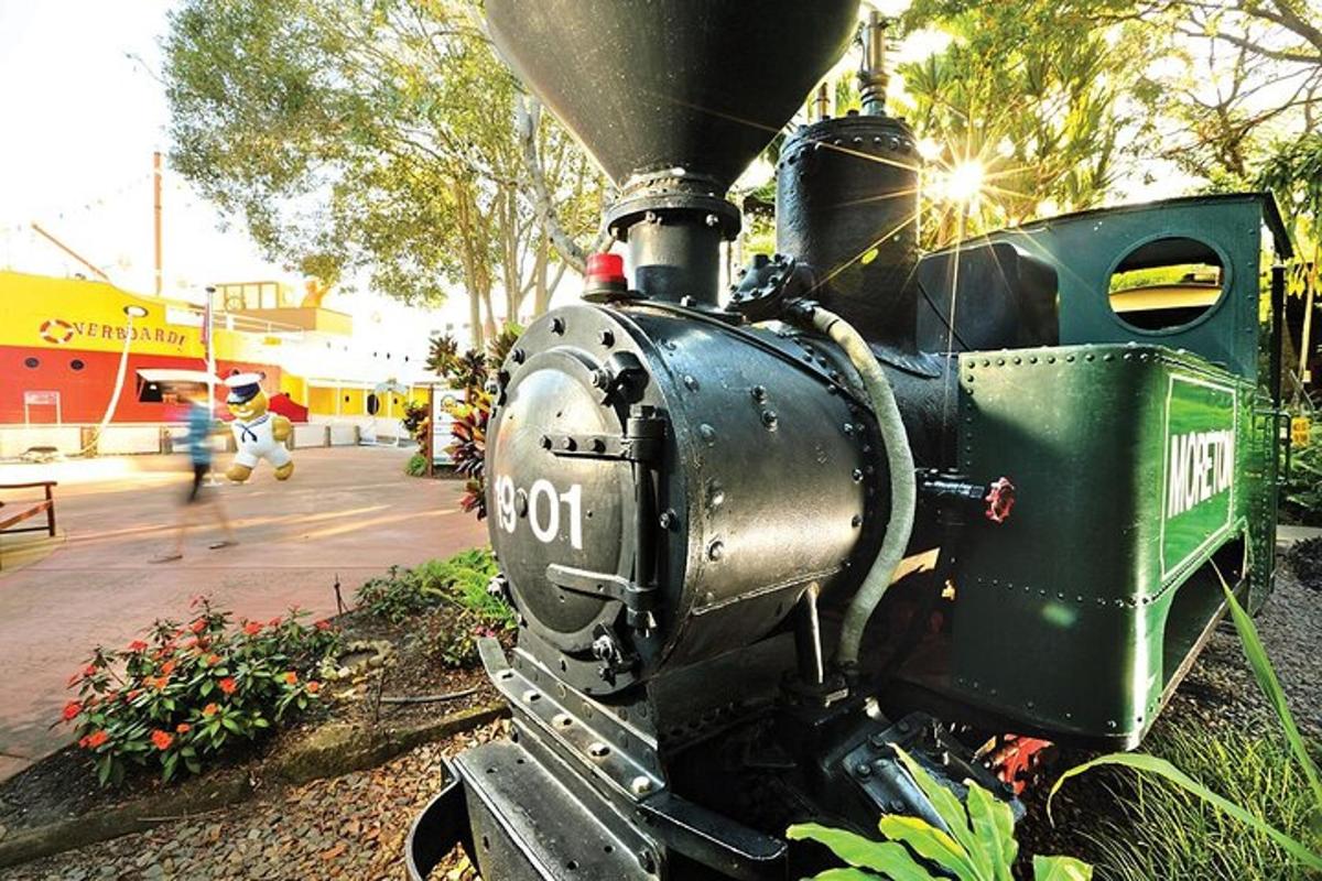 a green train engine sitting on the side of a street