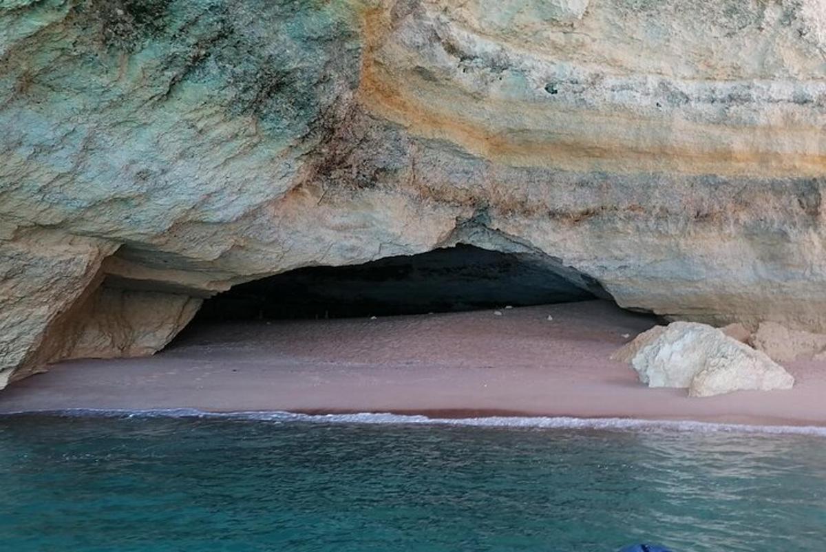 eine Höhle an einem Strand neben dem Wasser