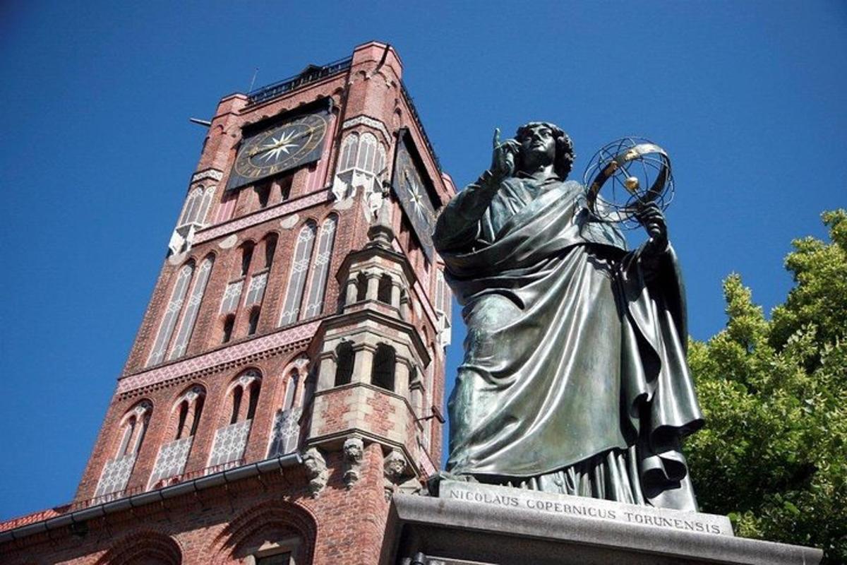 a statue in front of a building with a clock tower