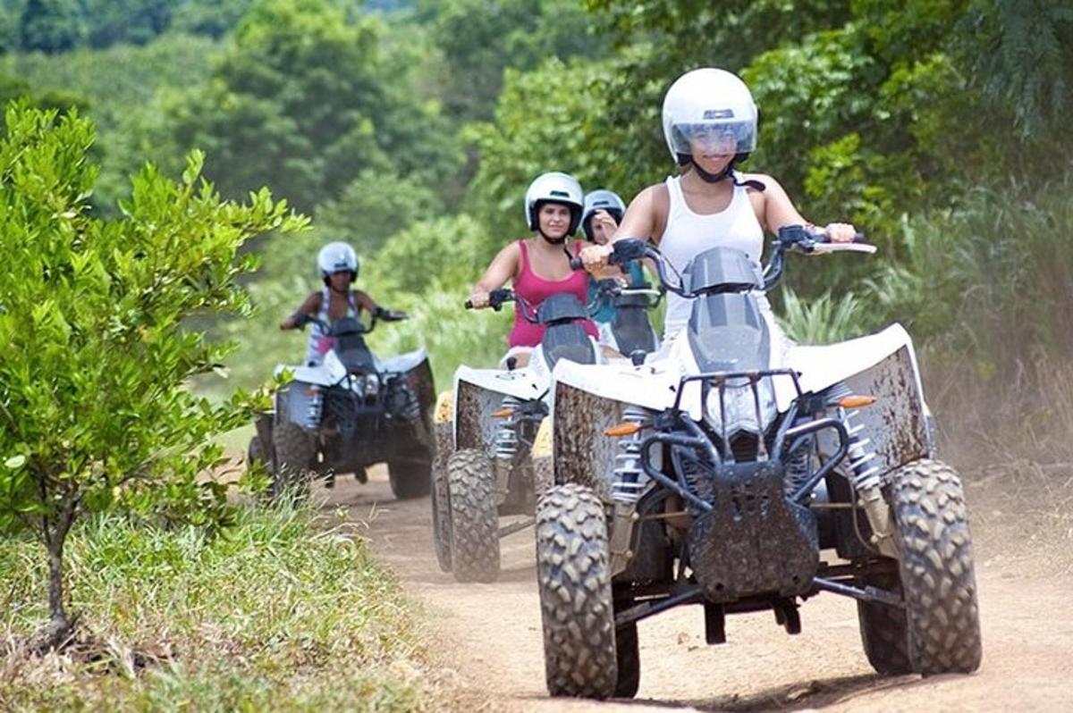 un gruppo di persone che guidano quad su una strada sterrata