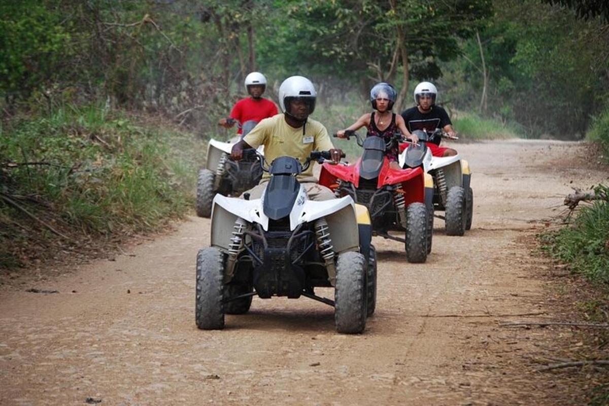 un gruppo di persone che guidano quad su una strada sterrata
