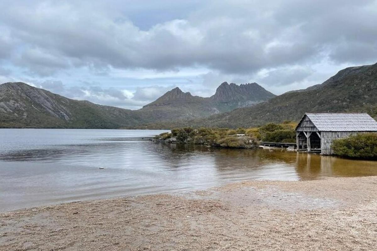 una casa sulla riva di un lago con montagne