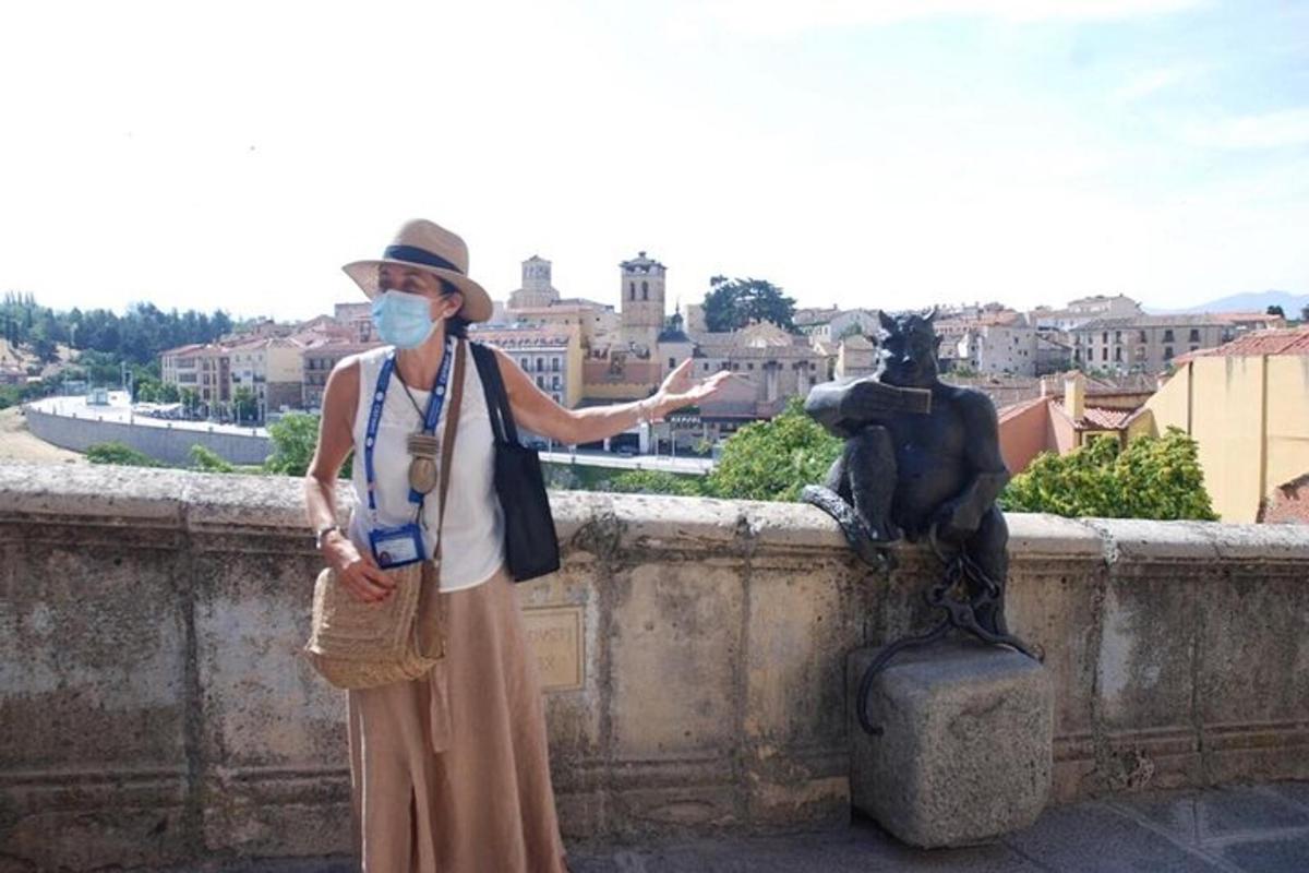 žena v masce stojící vedle sochy