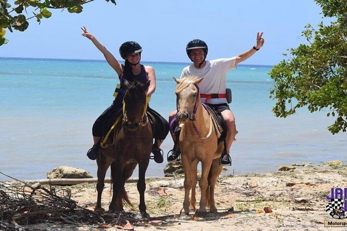 seorang pria dan seorang wanita menunggang kuda di pantai