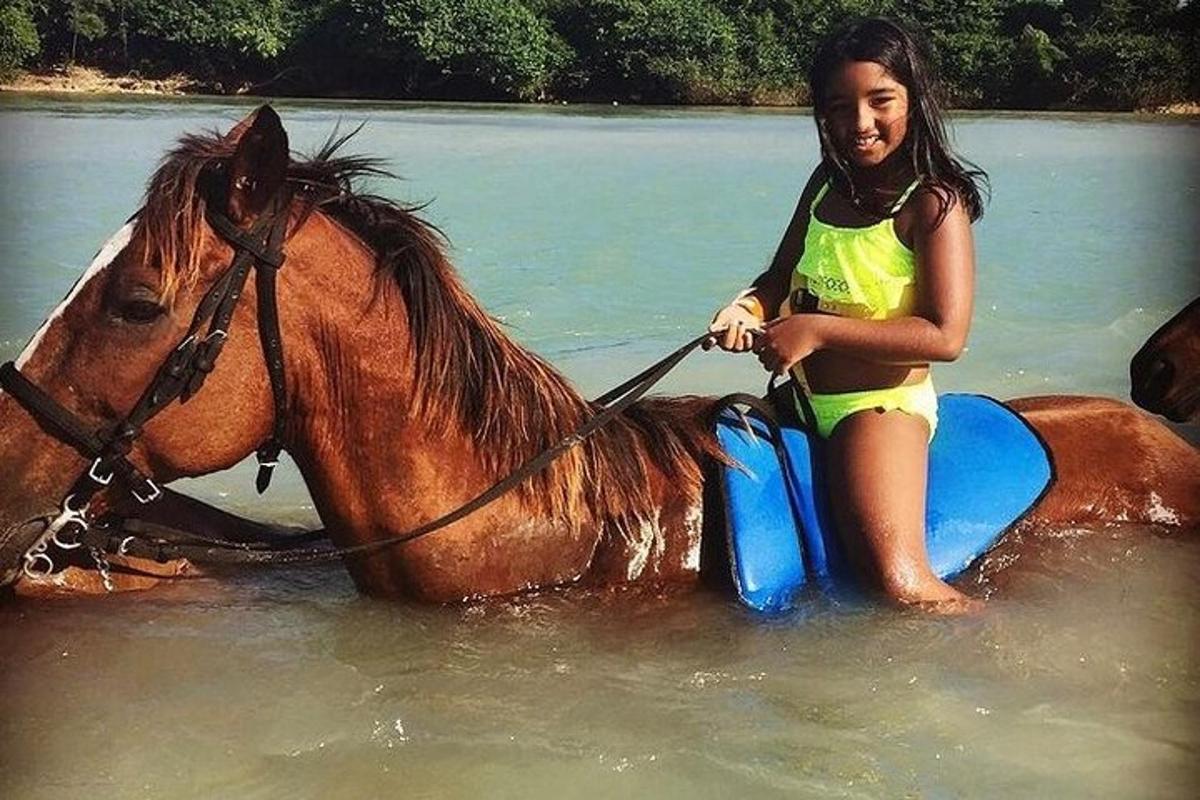 seorang gadis muda duduk di atas kuda di dalam air