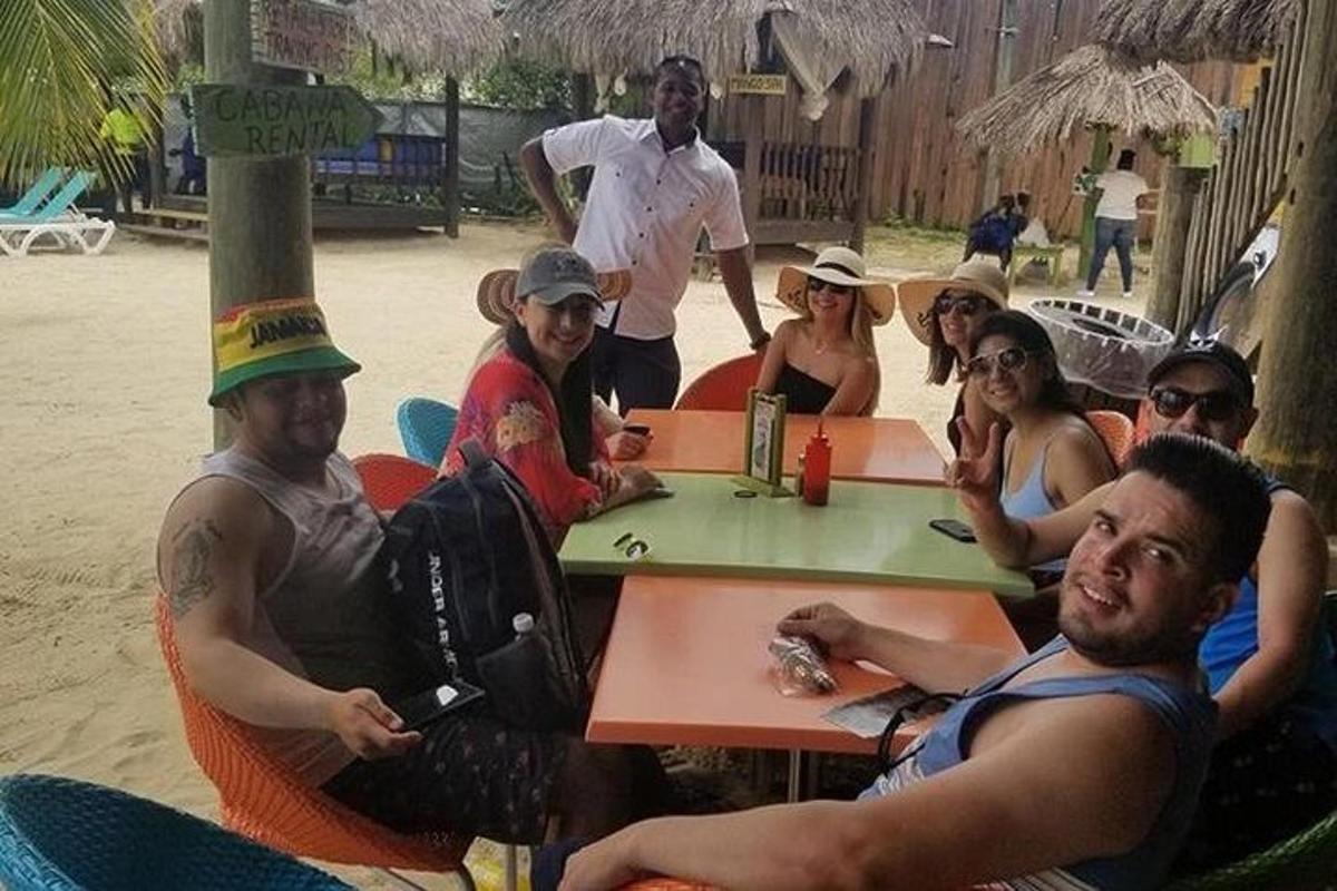 sekumpulan orang duduk di meja di pantai