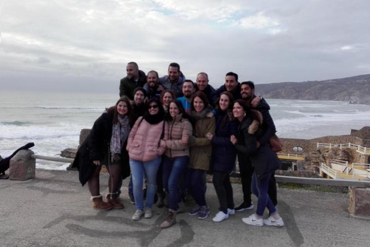 a group of people posing for a picture at the ocean