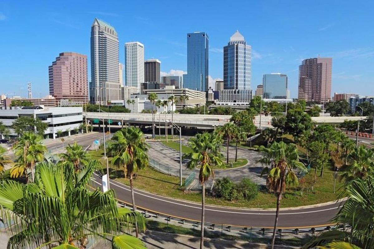 a city skyline with palm trees and a road