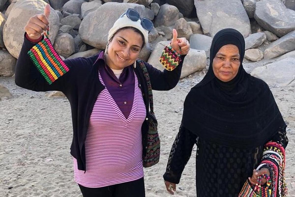 to kvinner som gir tommelen opp mens de står på stranden