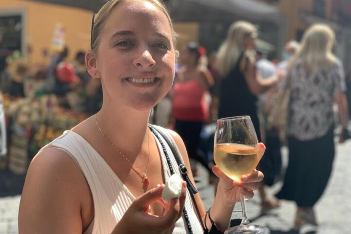 a woman holding a glass of white wine