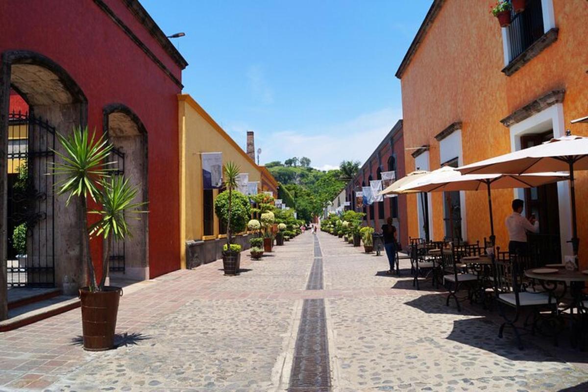 Una calle vacía con mesas, sillas y edificios.