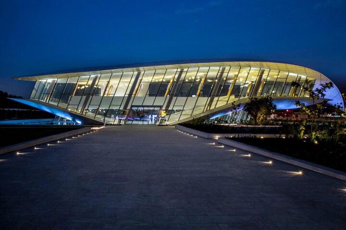 um grande edifício de vidro à noite com luzes na frente