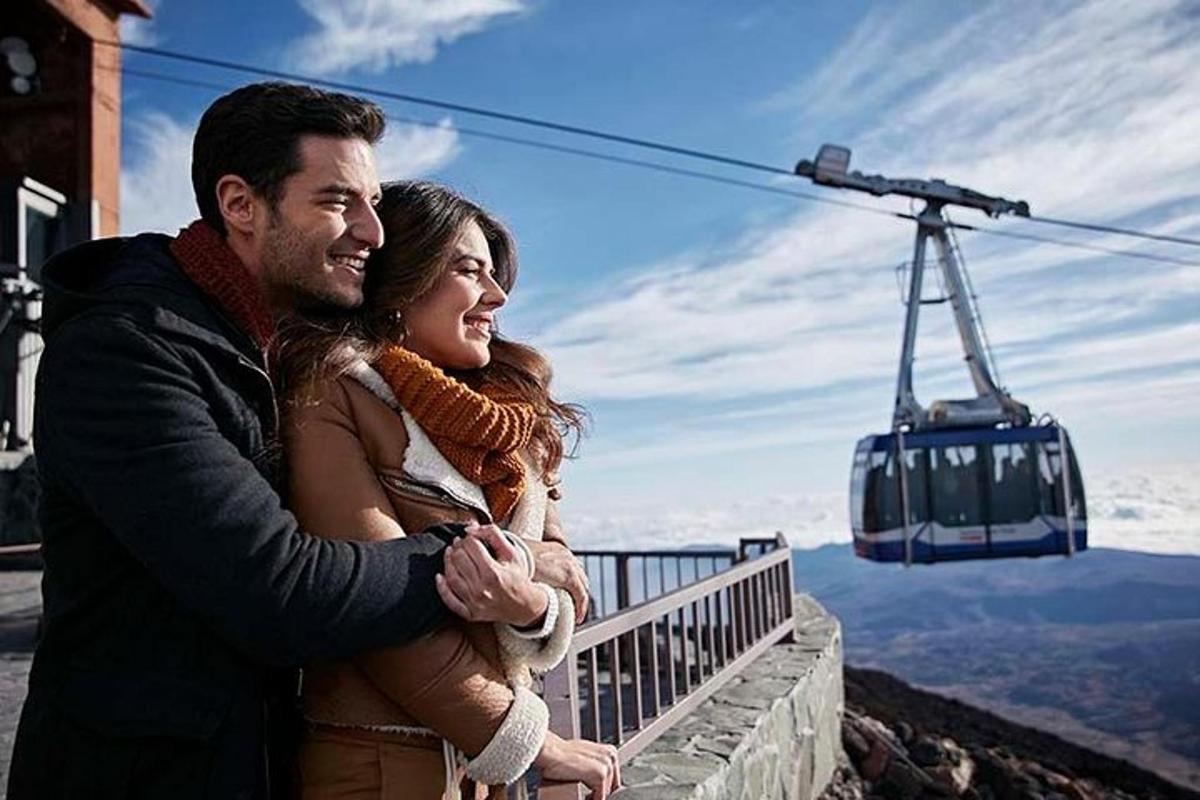 a man and a woman standing on top of a mountain