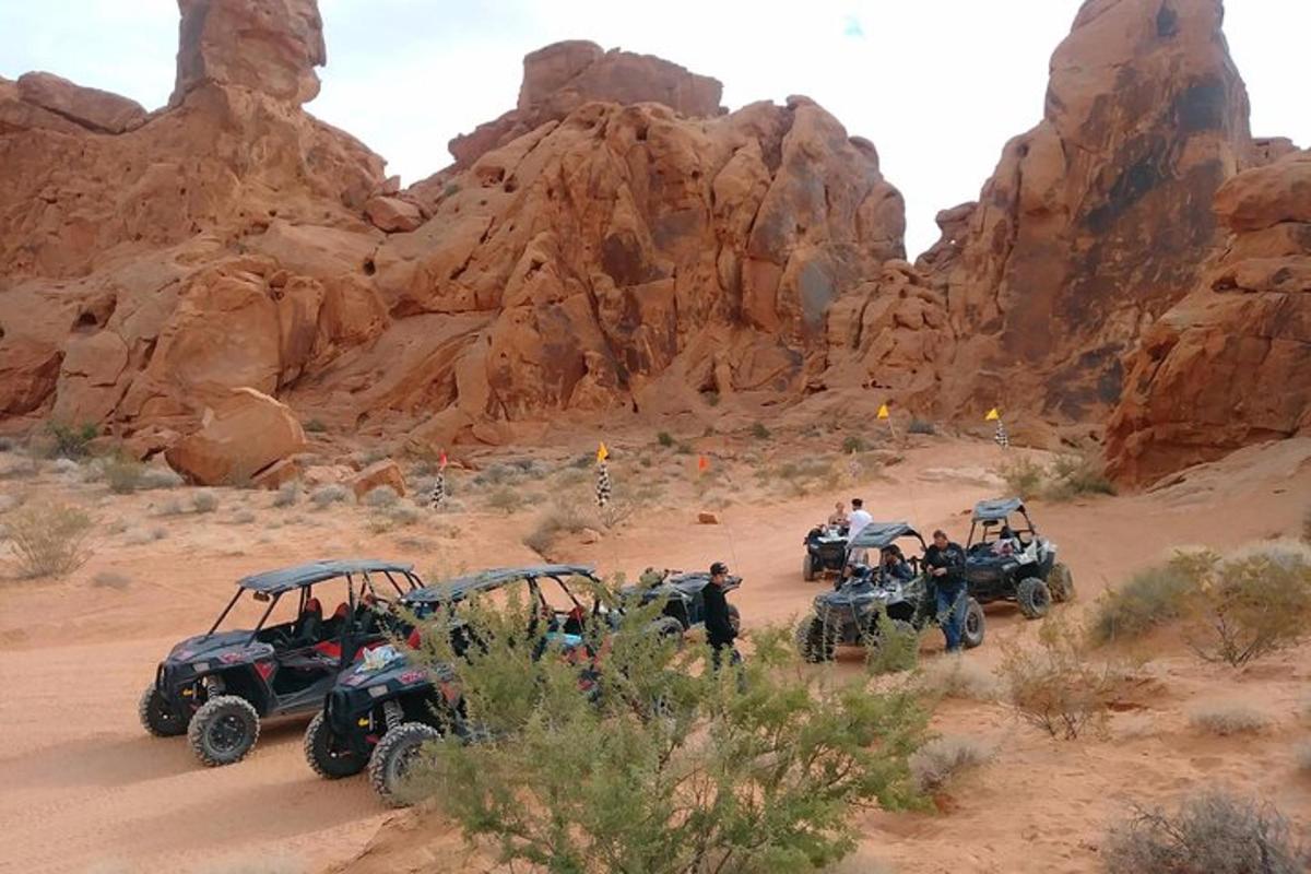 Çölde ATV'lerin etrafında duran bir grup insan