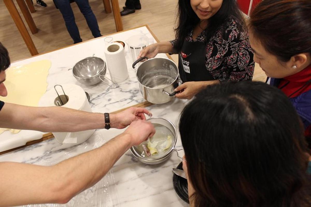 a group of people standing around a table preparing food