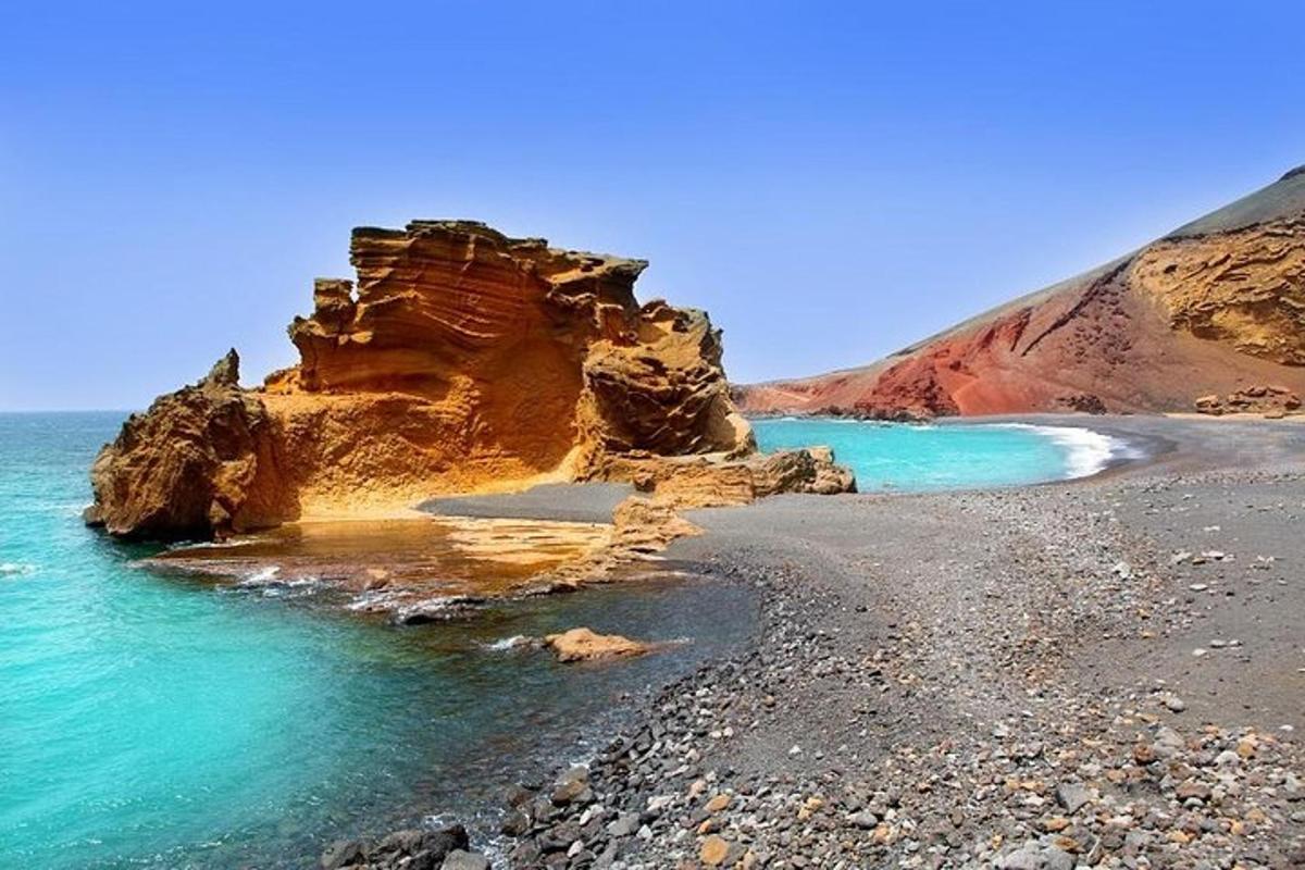 a beach with rocks and water and a cliff