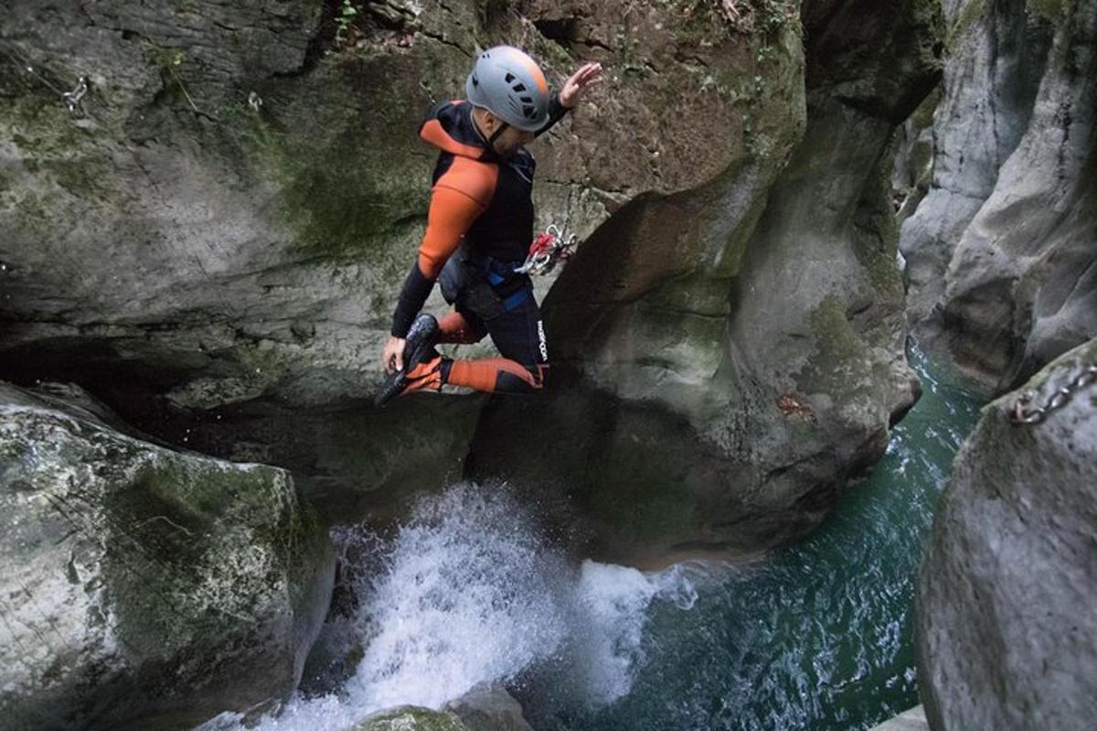 a man is jumping over a waterfall in a river