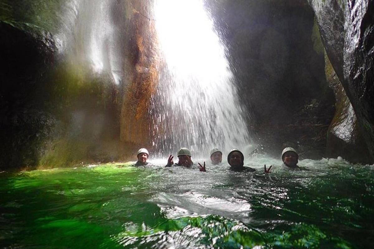 eine Gruppe von Menschen, die in einem Wasserfall schwimmen